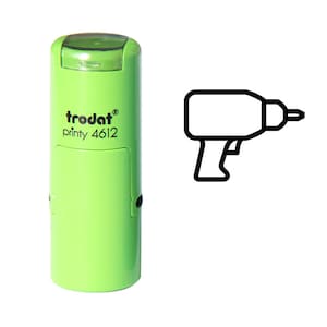 May include: A light green Trodat printy 4612 stamp with a black outline of a drill. The stamp has a rectangular design with rounded edges and a clear top. The drill outline is a simple, graphic representation.