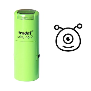 May include: Green self-inking stamp with a black and white illustration of a one-eyed alien with antennae. The stamp is labelled "trodat printy 4612".
