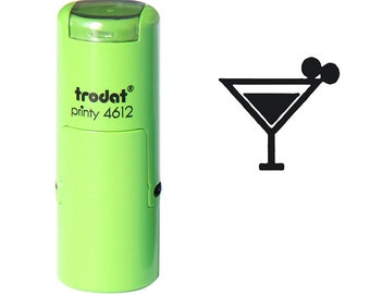 May include: Green self-inking stamp with the text "trodat printy 4612" and a black silhouette of a martini glass with a cherry on the rim.