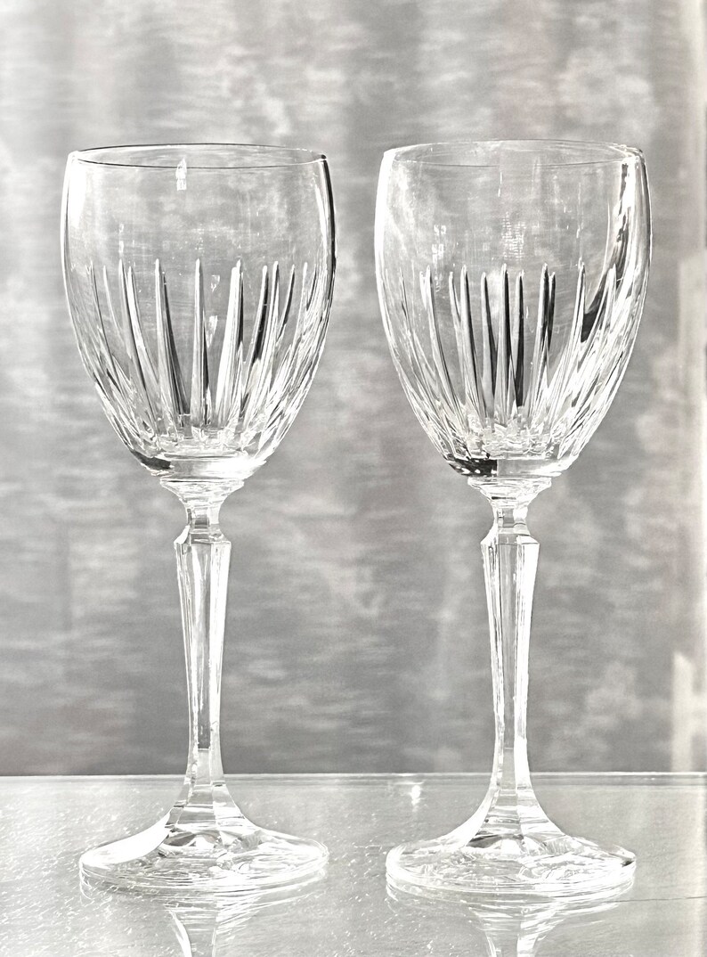 Pode incluir: Duas ta&ccedil;as de vinho de vidro transparente com um design de cristal cortado. As ta&ccedil;as t&ecirc;m um caule alto e uma tigela redonda.