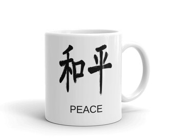 May include: White ceramic mug with black calligraphy that reads "和平" and the word "PEACE" below it.