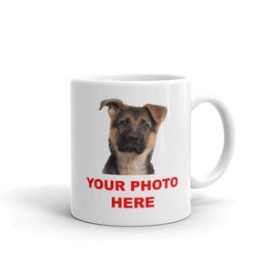 A white ceramic mug with a printed image of a dog's face and the text "YOUR PHOTO HERE" printed on it.