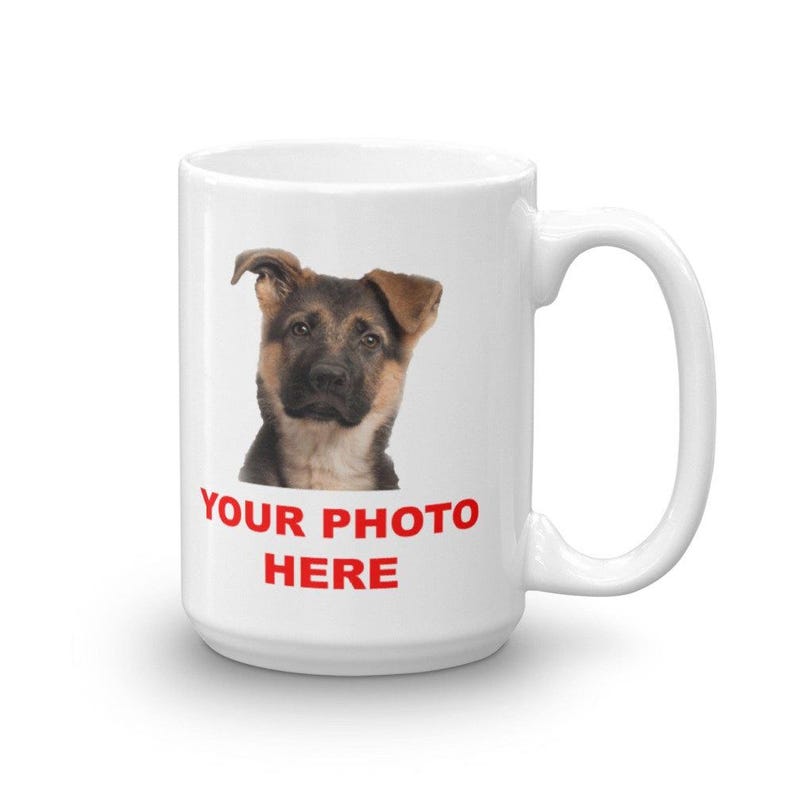 A white ceramic mug with a printed image of a dog's face and the text "YOUR PHOTO HERE" printed on it.