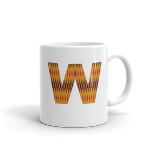 May include: White ceramic mug with a large letter "W" printed on the front. The letter is in a colourful African print pattern with yellow, orange, red, green, and black colours.