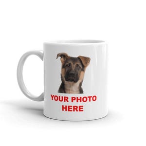 A white ceramic mug with a printed image of a dog's face and the text "YOUR PHOTO HERE" printed on it.