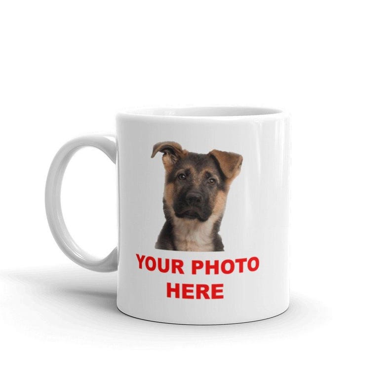 A white ceramic mug with a printed image of a dog's face and the text "YOUR PHOTO HERE" printed on it.