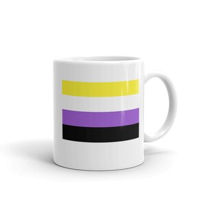 Puede incluir: Taza de cerámica blanca con un diseño de rayas horizontales amarillas, moradas y negras. La taza tiene un asa en el lado derecho.