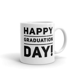May include: White ceramic mug with the text "HAPPY GRADUATION DAY!" in bold black letters. The mug has a curved handle and is set against a white background. A celebratory gift for graduates.