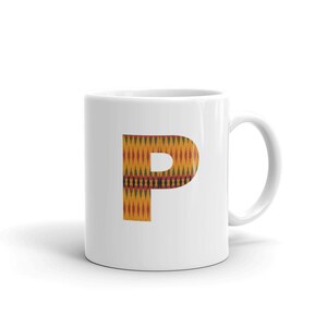 Può includere: Tazza in ceramica bianca con una grande lettera "P" stampata sul davanti. La lettera è in un motivo geometrico giallo, rosso, verde e nero.