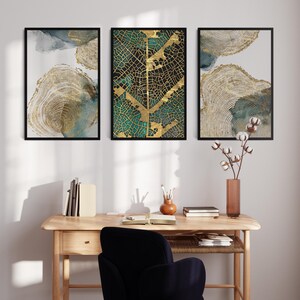 Puede incluir: Tres impresiones de arte abstracto enmarcadas con colores dorados y verdes. La impresi&oacute;n central presenta un dise&ntilde;o de hoja de oro sobre un fondo verde. Las impresiones est&aacute;n colgadas en una pared blanca sobre un escritorio de madera con una silla negra.