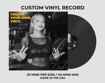 Op de afbeelding: Een aangepaste vinylplaat met een zwart-witte vierkante hoes met de tekst CUSTOM VINYL RECORD, CREATE YOUR OWN VINYL, en 20 MINS PER SIDE / 40 MINS MAX MADE IN THE USA. De hoes toont een persoon in een crop top en de plaat heeft een A-label.