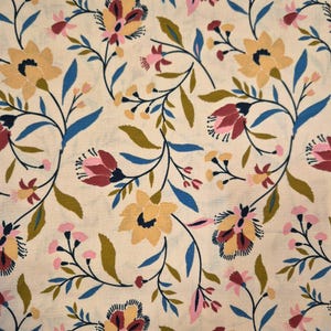 Puede incluir: Tela color crema con un estampado floral repetido. El diseño presenta flores estilizadas en amarillo, rosa y burdeos, con hojas y tallos azules y verdes. La estética general recuerda a los estilos vintage o cottagecore.