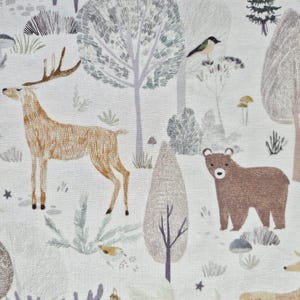 Può includere: Un tessuto con un design a scena boschiva. Il motivo presenta un cervo marrone, un orso, uccelli, alberi e fogliame in tonalità di marrone, verde e grigio su sfondo bianco. Il design ha uno stile stravagante e illustrato.