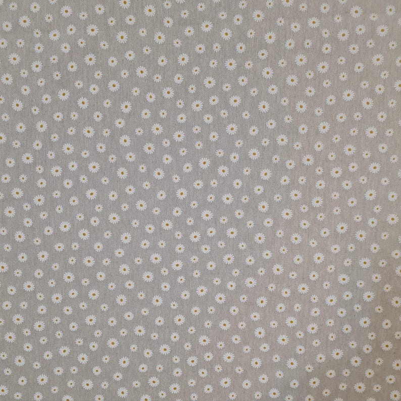 May include: A close-up of a light grey fabric with a repeating pattern of small white daisies.