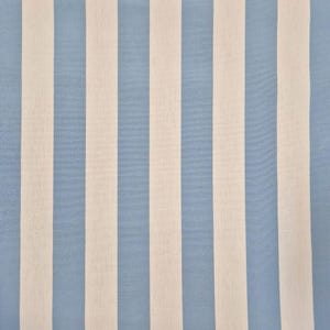 Pode incluir: Um tecido com um padrão repetitivo de listras verticais. As listras alternam entre azul claro e creme. O tecido tem uma aparência macia e texturizada.