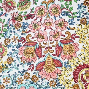 May include: A white fabric with a floral pattern. The pattern features pink, red, yellow, and blue flowers with intricate details. The background is white with a subtle texture.