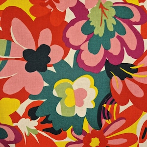 May include: A vibrant floral fabric featuring large, stylized flowers in shades of red, pink, teal, yellow, and purple. The design has a retro, bold aesthetic with a cream-colored background. The flowers have a layered, almost 3D effect, creating a lively and colorful pattern.
