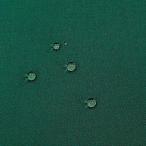 Könnte beinhalten: Nahaufnahme eines dunkelgrünen Stoffes mit vier Wassertropfen auf der Oberfläche.