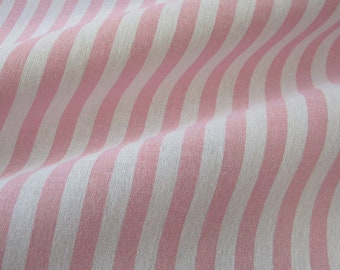 May include: Close-up of a fabric with vertical stripes in alternating shades of white and light pink. The fabric is slightly wrinkled, creating soft shadows and a textured appearance. The stripes are evenly spaced.