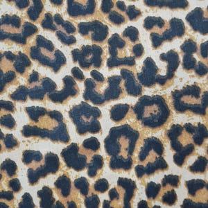 Op de afbeelding: Close-up van een stof met een bruin en zwart luipaardprintpatroon.