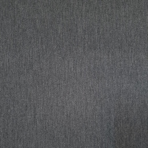 May include: A close-up view of a dark grey fabric with a textured surface. The material displays a subtle woven pattern, with tonal variations adding depth. The fabric appears to be of medium weight, suitable for clothing or home furnishings.
