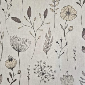 Könnte beinhalten: Ein Stoff mit einem sich wiederholenden Blumenmuster. Das Design zeigt verschiedene botanische Illustrationen in Braun- und Beigetönen, darunter Blumen, Blätter und Stiele, vor einem hellbeigen Hintergrund. Der Stil erinnert an eine botanische Zeichnung.