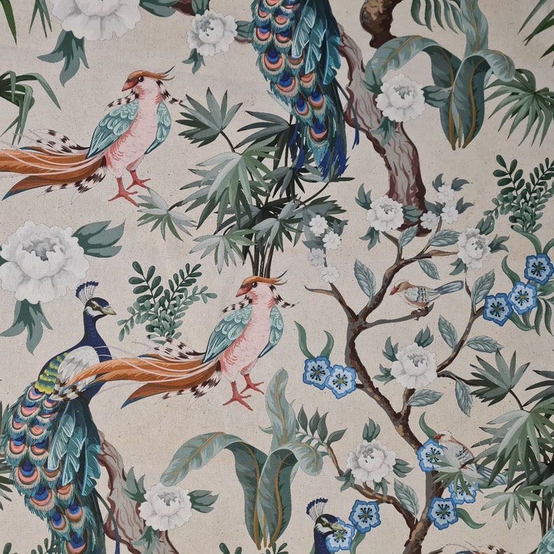 Pu&ograve; includere: Un tessuto beige con un motivo ripetitivo di pavoni, uccelli e disegni floreali. I pavoni sono blu e verdi con motivi intricati. Gli uccelli sono arancioni, marroni e bianchi. I fiori sono bianchi e rosa.