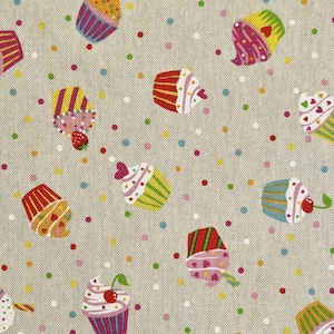 Könnte beinhalten: Ein beigefarbener Stoff mit einem sich wiederholenden Muster aus bunten Cupcakes mit Streuseln und Kirschen. Die Cupcakes sind in verschiedenen Farben, darunter rosa, blau, grün, gelb und rot.