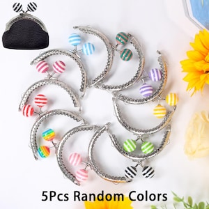 Puede incluir: Un conjunto de cierres de bolso plateados con detalles de bolas a rayas de colores. Los cierres están dispuestos en forma circular, con un bolso negro texturizado en la esquina superior izquierda. El texto "5Pcs Random Colors" está en la parte inferior.