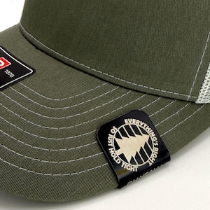 May include: Olive green trucker hat with a white mesh back. The hat features a curved brim and a small tag that reads "EVERYTHING'S RIGHT". The Richardson brand label is also visible. Adjustable fit.