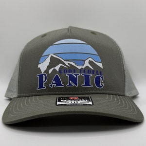 May include: A gray trucker hat with a blue and white mountain sunset graphic and the text "Good People Panic" in blue.