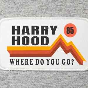 May include: Rectangular patch with the text "HARRY HOOD" in black block letters above "WHERE DO YOU GO?" The design includes a mountain graphic in orange and yellow, and a circle with the number "85".