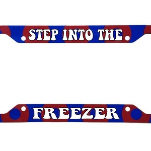 May include: A blue and red license plate frame with a white background and the text "STEP INTO THE FREEZER".