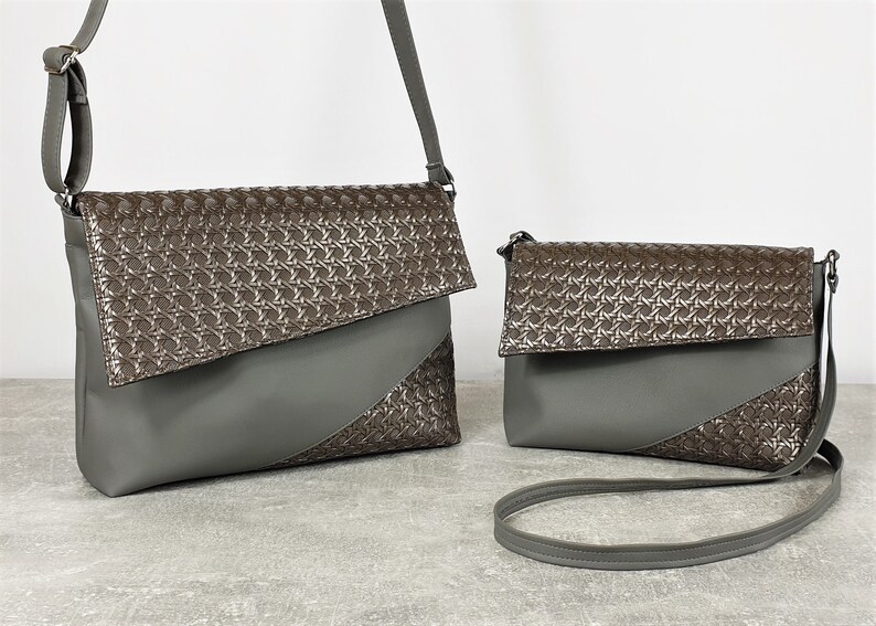 Puede incluir: Dos bolsos cruzados grises. El bolso m&aacute;s grande tiene una correa larga ajustable, y el bolso m&aacute;s peque&ntilde;o tiene una correa para el hombro. Ambos bolsos presentan un patr&oacute;n geom&eacute;trico en la solapa y un dise&ntilde;o diagonal en la parte delantera.