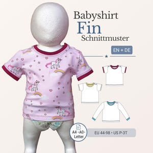 Könnte beinhalten: Ein rosa Baby-T-Shirt mit Einhorn-, Regenbogen- und Sternmotiven. Das Shirt hat einen bordeauxfarbenen Besatz an den Ärmeln und am Halsausschnitt. Der Text "Babyshirt Fin Schnittmuster" ist abgebildet. Größe EU 44-98, US P-3T.