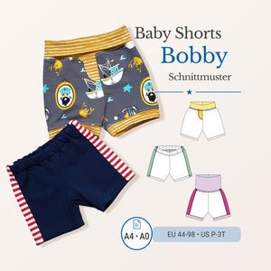 May include: Two pairs of baby shorts. One pair is navy blue with red and white stripes on the sides. The other pair is grey with a nautical print of boats and a sailor. The text "Baby Shorts Bobby Schnittmuster" is displayed.