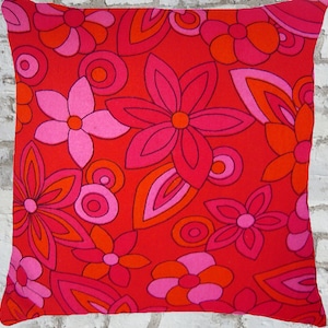 May include: Red and pink floral cushion cover with a retro 1970s style pattern.