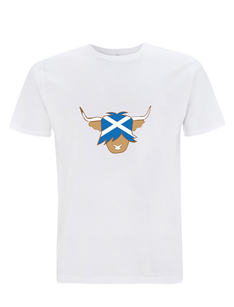 May include: White t-shirt with a brown Highland cow illustration. The cow's face is covered by a blue and white Scottish flag.