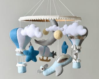 Karuzela z filcu w kształcie samolotu z helikopterem. Karuzela dla niemowląt z motywem lotniczym: balon na ogrzane powietrze, samolot i chmury na niebie. Prezent na baby shower dla chłopca.