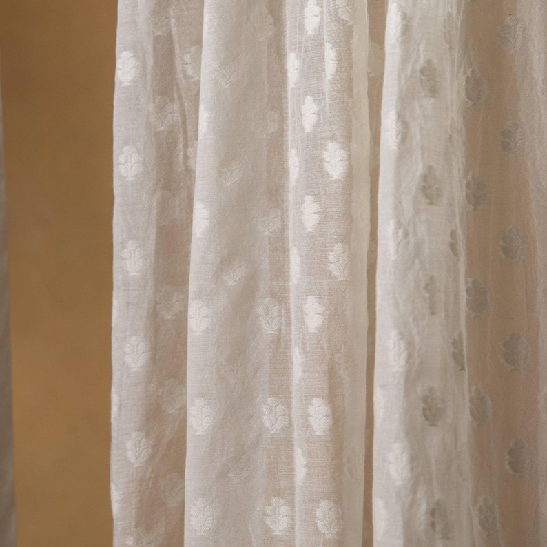May include: White sheer curtains with an embossed floral pattern.
