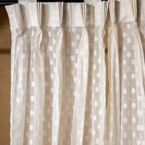 May include: White sheer curtains with a small floral pattern. The curtains are hung on a black curtain rod.