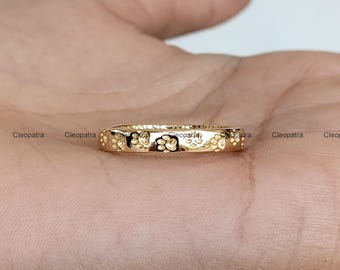 May include: A gold band ring with a paw print design. The ring is thin and has a polished finish.