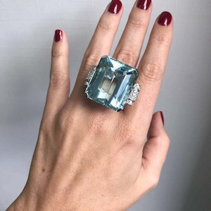 Anello nuziale con acquamarina a forma di smeraldo grande da 80,35 carati e accenti in zirconia cubica