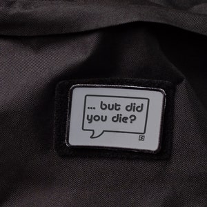 May include: Black backpack with a black patch that says "... but did you die?" in white text.
