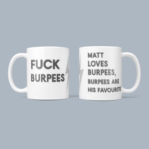 May include: Two white ceramic mugs with a black lightning bolt design. One mug says "FUCK BURPEES" and the other mug says "MATT LOVES BURPEES, BURPEES ARE HIS FAVOURITE".