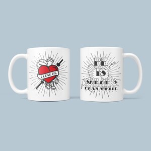 May include: White ceramic mug with a black and white illustration of a heart with the text "I love PE" and a dumbbell, barbell, and basketball. The other side of the mug has the text "PE is Sarah's Favourite" in black and white.