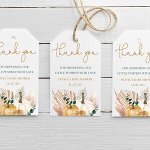 May include: Three white thank you tags with gold lettering. Each tag features a watercolour illustration of pumpkins, pampas grass, and greenery. The text on the tags reads "Thank you" and "For showering our little pumpkin with love, Olivia's Baby Shower, 11.27.20".