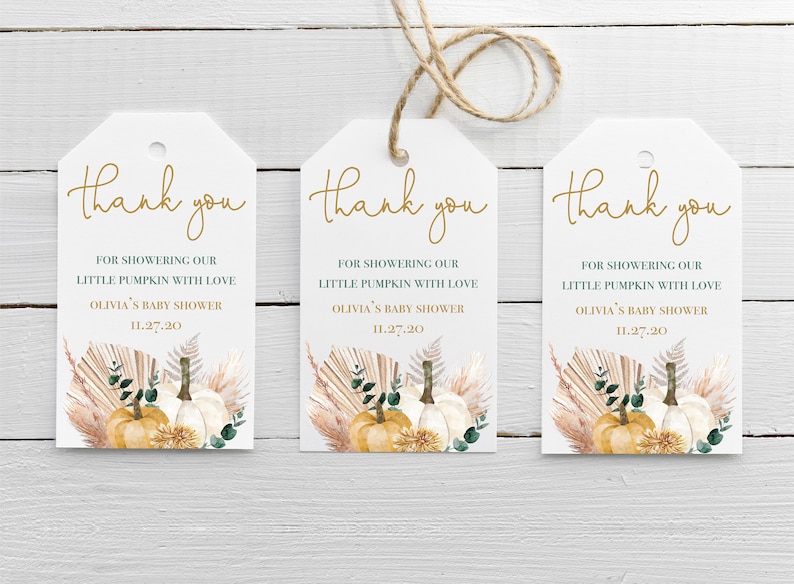 May include: Three white thank you tags with gold lettering. Each tag features a watercolour illustration of pumpkins, pampas grass, and greenery. The text on the tags reads "Thank you" and "For showering our little pumpkin with love, Olivia's Baby Shower, 11.27.20".