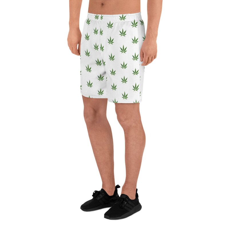 May include: White athletic shorts with a green marijuana leaf pattern.