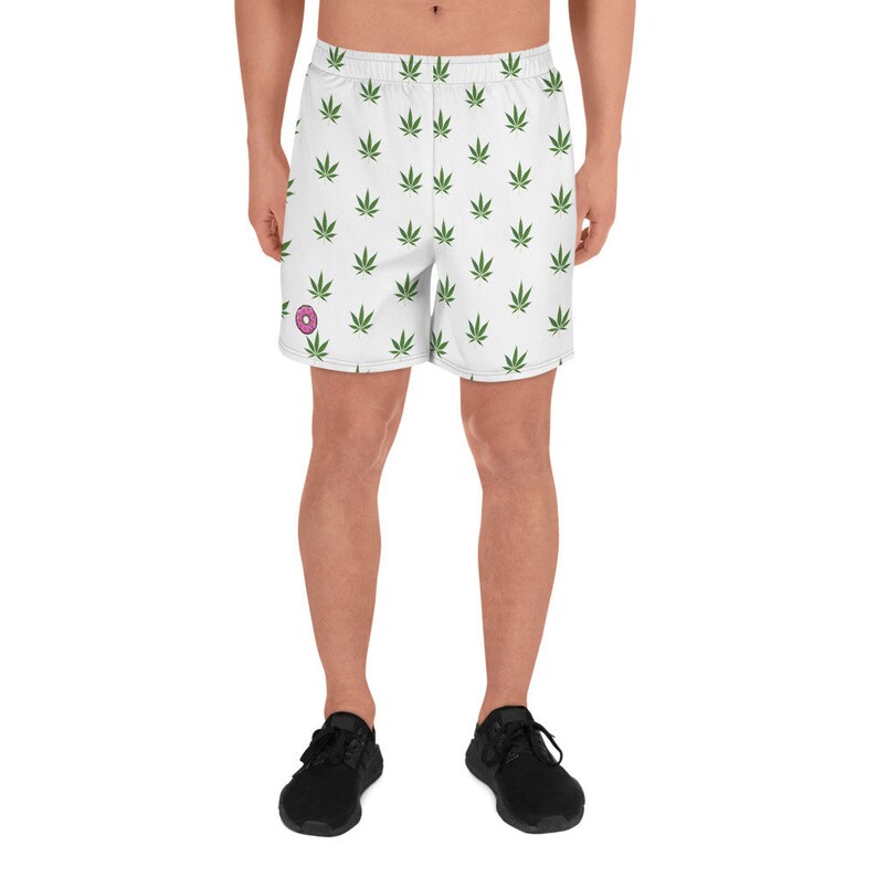May include: White athletic shorts with a green marijuana leaf pattern. A pink donut is visible on the left leg.